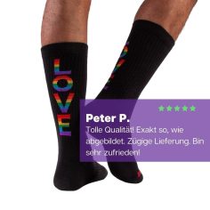 Füße mit schwarzen Pride Tennissocken und buntem LOVE Schriftzug von PATRON SOCKS