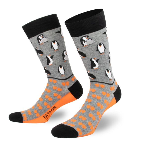 Verspielte graue Pinguin-Socken mit fröhlichen orangen Fußspuren von PATRON SOCKS